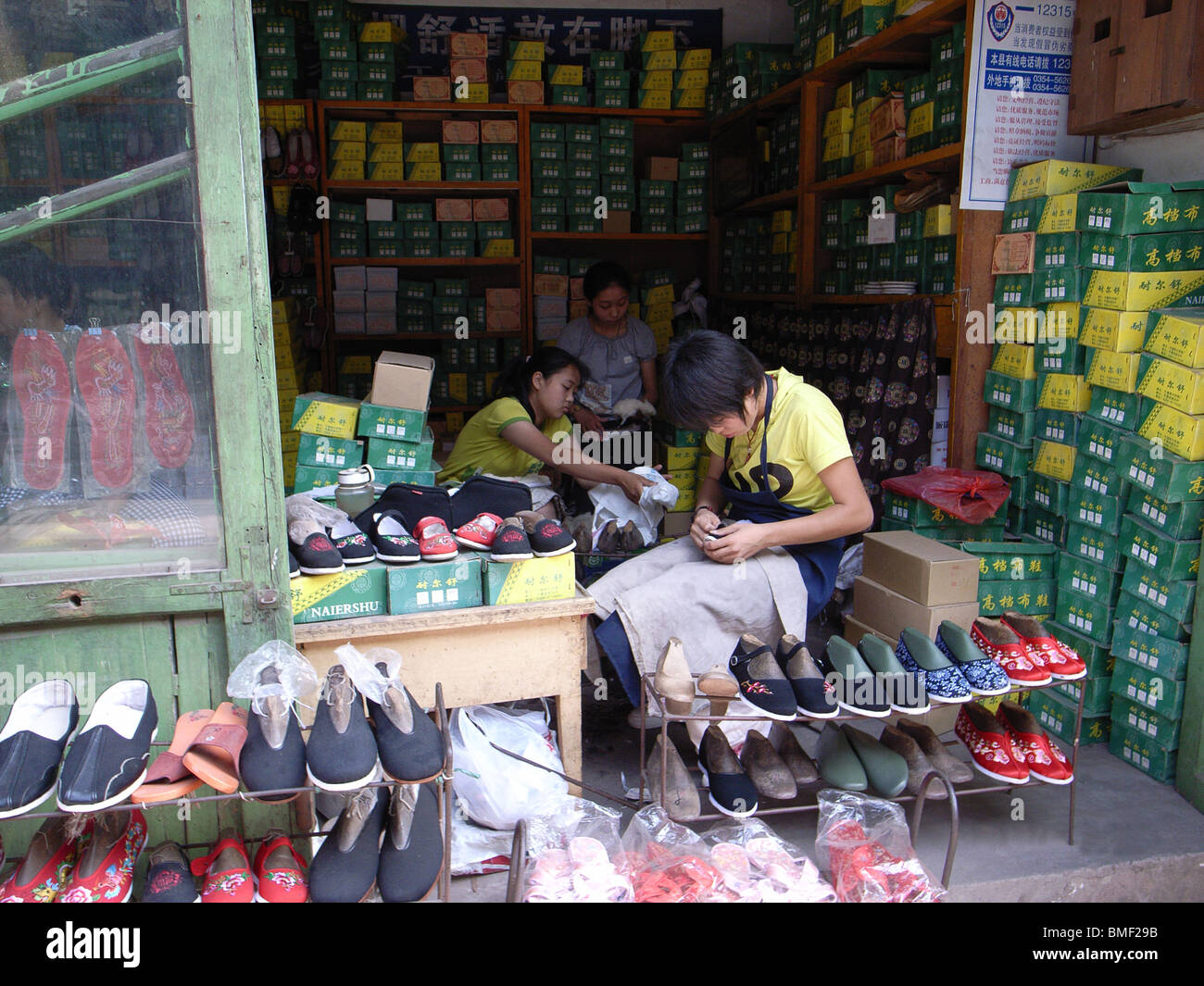 La fabrication des chaussures des femmes en utilisant la méthode traditionnelle dans le magasin, Pingyao, Shanxi Province, China Banque D'Images