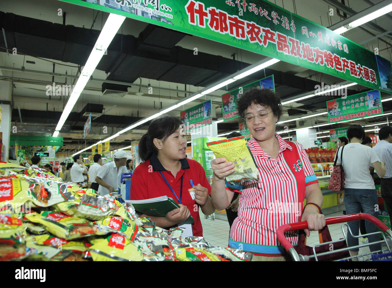 Greffier introduire un produit à un client au niveau de l'exploitation Produits Fair, Beijing, Chine Banque D'Images