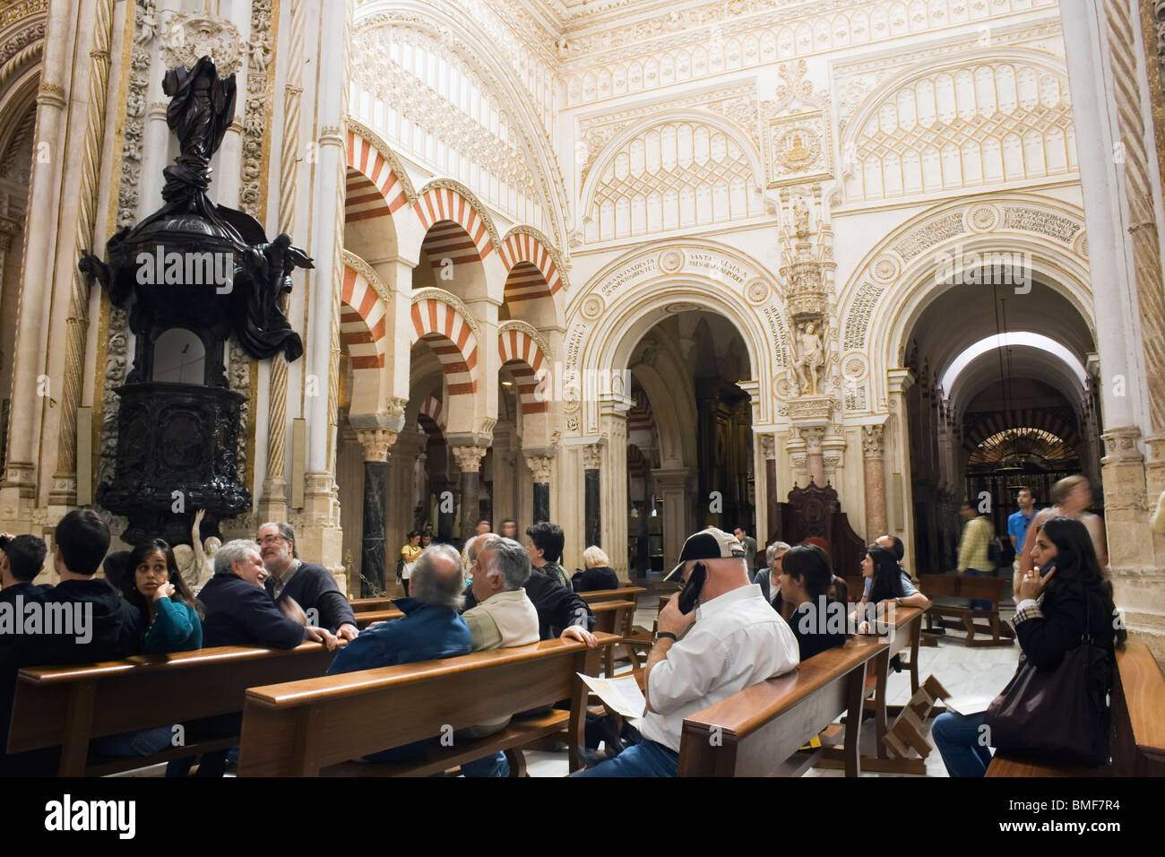 La Grande Mosquée, Cordoba, Espagne. Les touristes assis à écouter des audio guides expliquant l'architecture de la mosquée. Banque D'Images