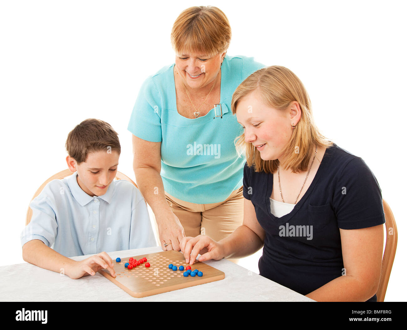 La mère et deux enfants jouer à des jeux de société. Isolé sur blanc. Banque D'Images