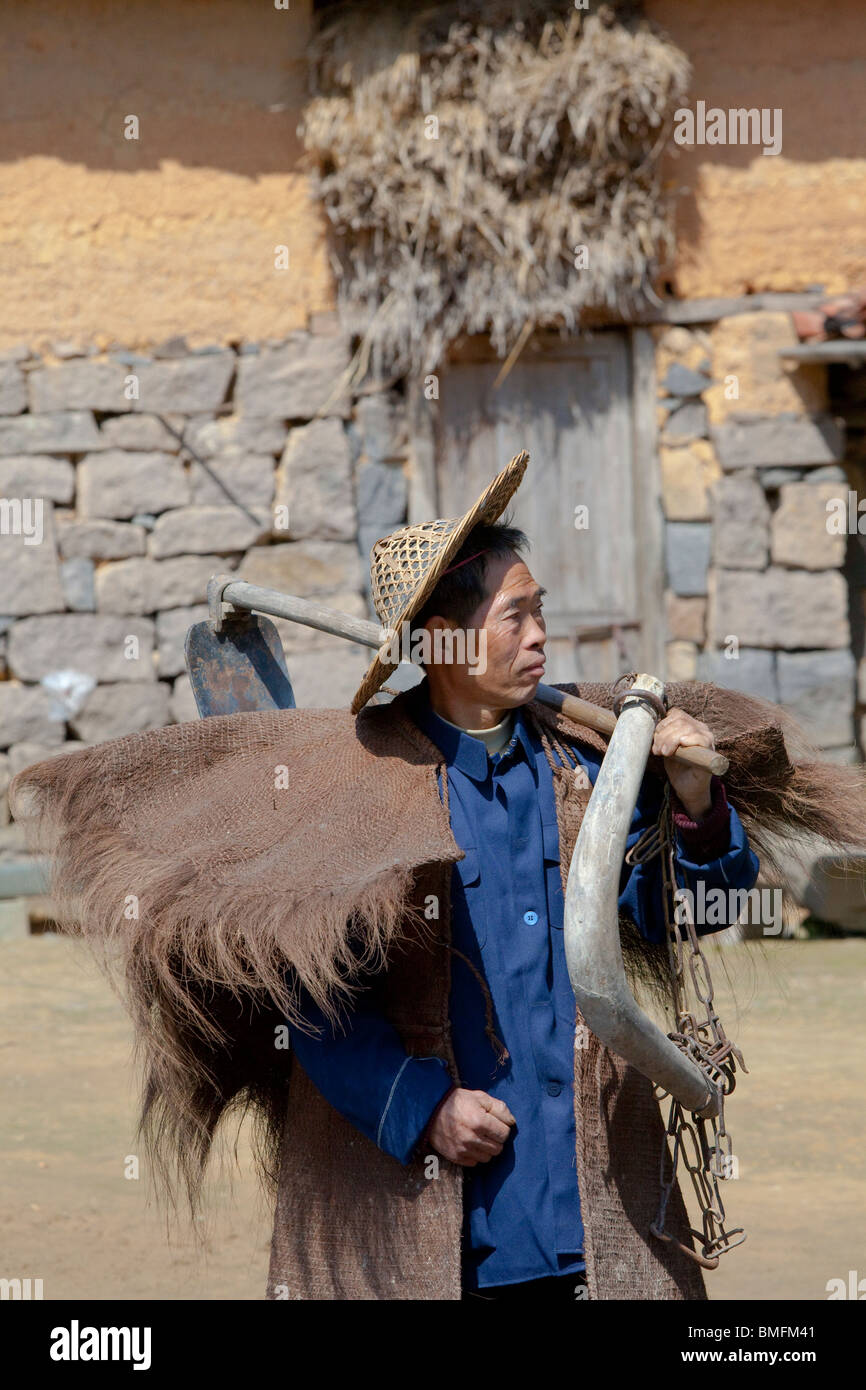 Elle l'homme de paille en cape de pluie, Banling Village, Zhengkeng, Jingning comté autonome elle, Hangzhou, Zhejiang, Chine Banque D'Images