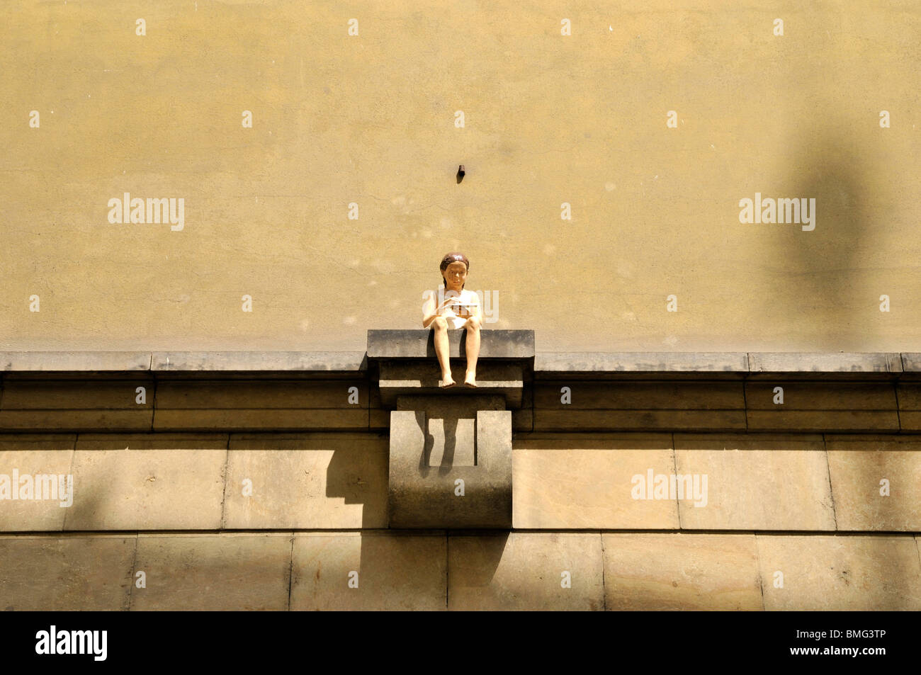 Sculpture de petite fille assise sur le mur, Prague République tchèque, est de l'Europe Banque D'Images