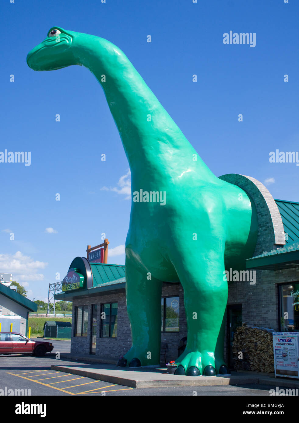 Une statue verte classique de dinosaure Sinclair se dresse devant une station-service dans Wisconsin Dells, une icône nostalgique de route d'Americana. Banque D'Images