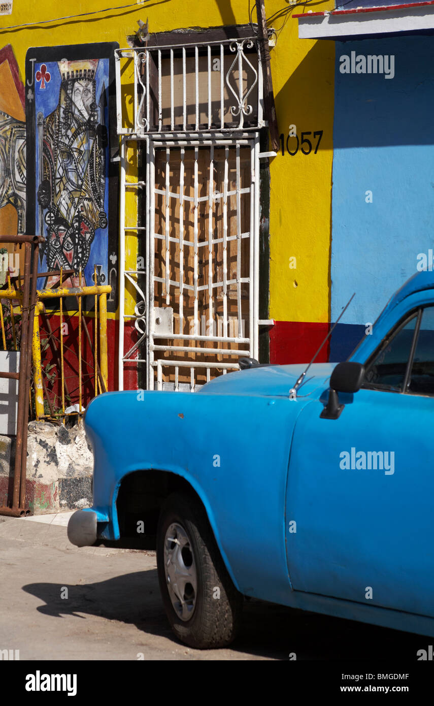Ancien bleu voiture garée dans la rue avec des œuvres peintes sur des bâtiments de Callejon de Hamel, La Havane, Cuba, Antilles, Caraïbes, Amérique Centrale Banque D'Images