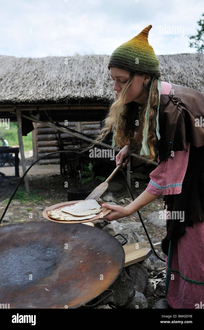 Femme en costume viking viking de Birka en cuisson sur Bjoerkoe ville de l'île, patrimoine mondial de l'UNESCO, la Suède Banque D'Images