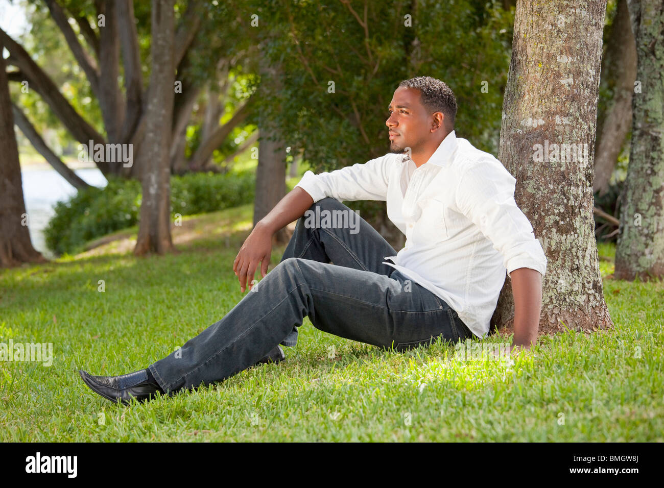 Fort Lauderdale, Floride, États-Unis d'Amérique ; Portrait d'un homme assis contre un arbre dans un parc Banque D'Images