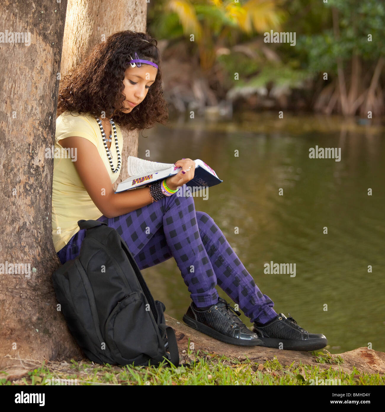 Fort Lauderdale, Floride, États-Unis d'Amérique ; une fille lire un livre sous un arbre Banque D'Images