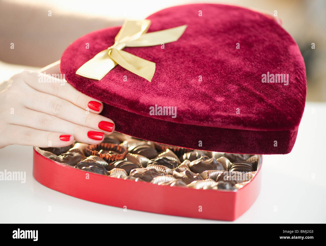 Part de l'ouverture d'un velvet boîte de chocolats en forme de coeur Banque D'Images