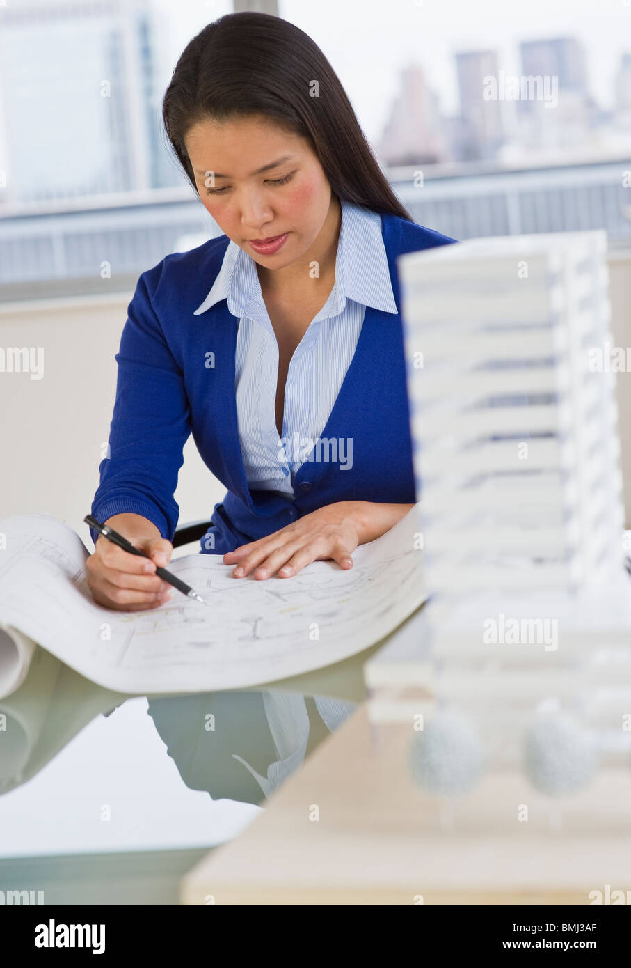 Female architect looking at blueprints Photo Stock - Alamy