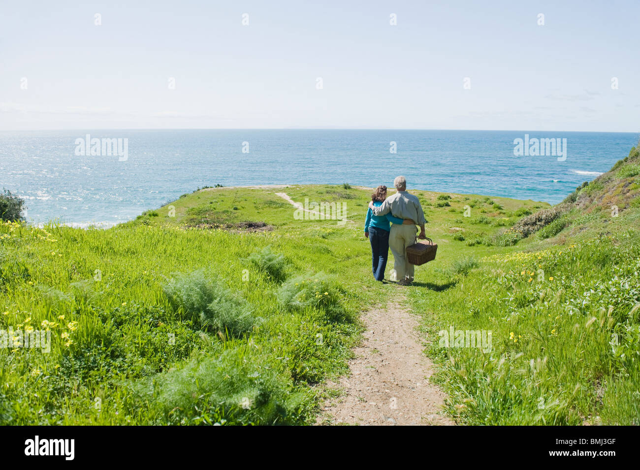 Couple carrying panier pique-nique à la plage Banque D'Images