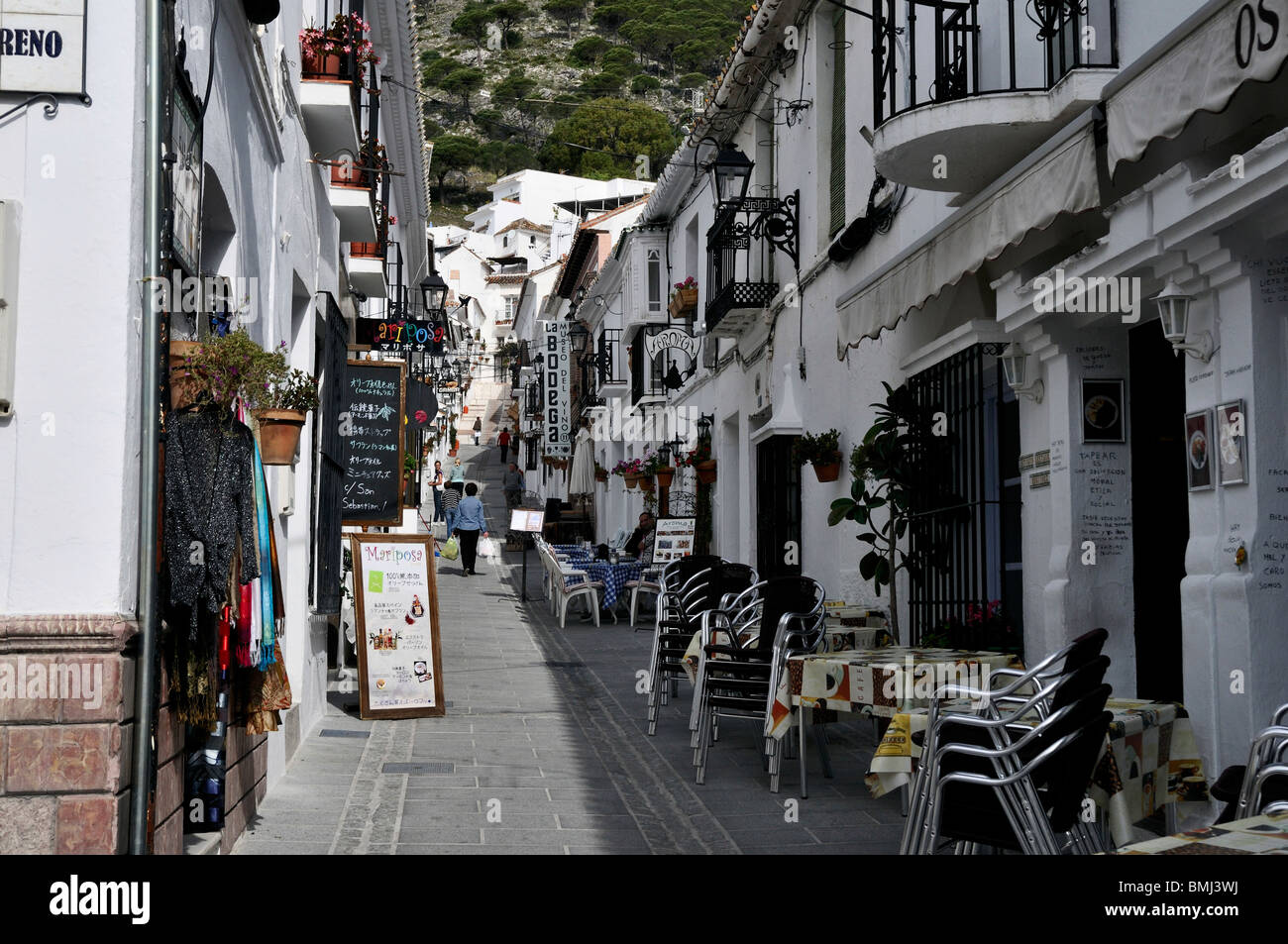 Une étroite rue pavée bordée de restaurants, magasins et magasins dans le village blanc de Mijas Pueblo Banque D'Images