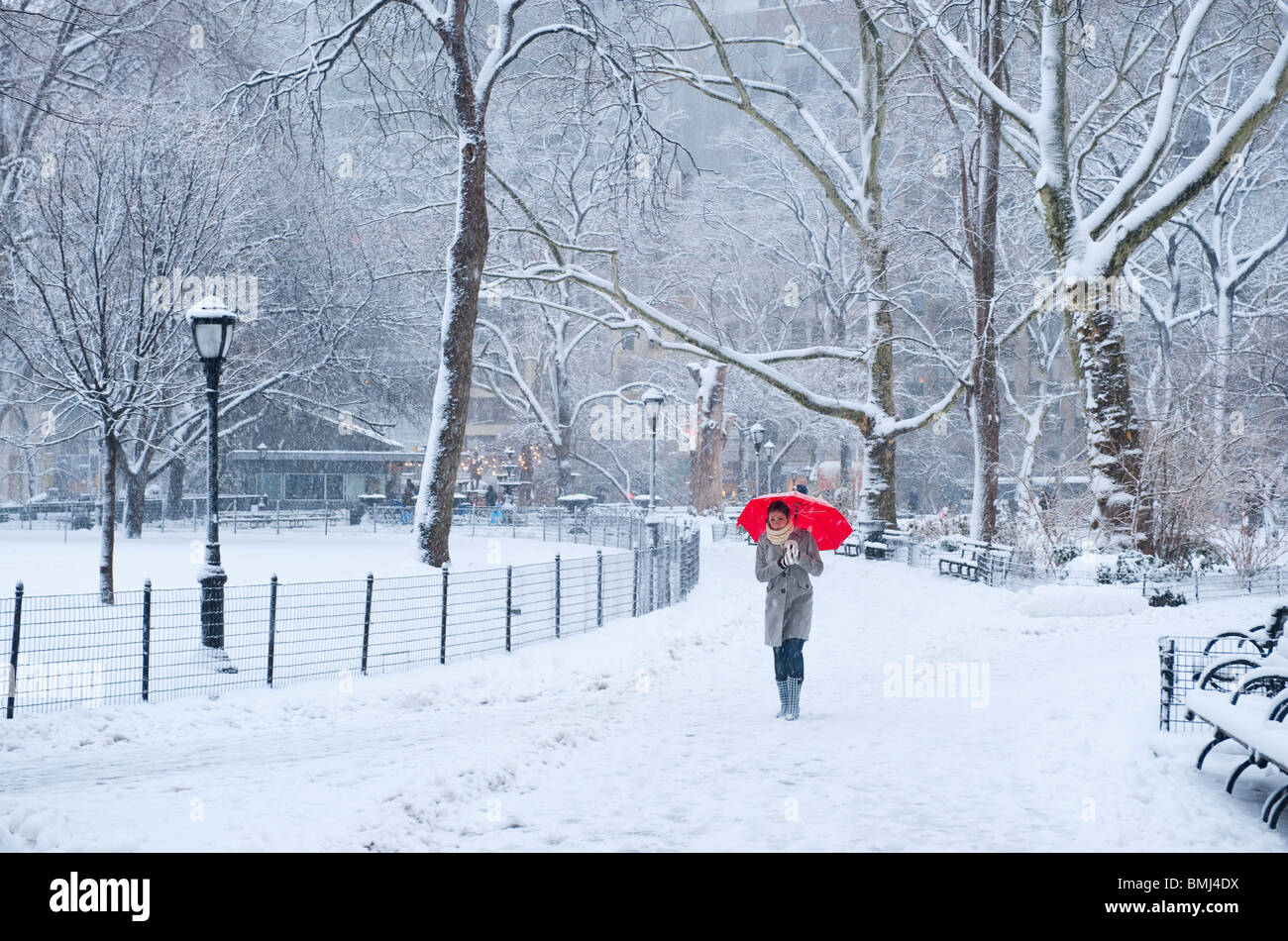 Femme marche avec parapluie rouge sur un jour de neige Banque D'Images
