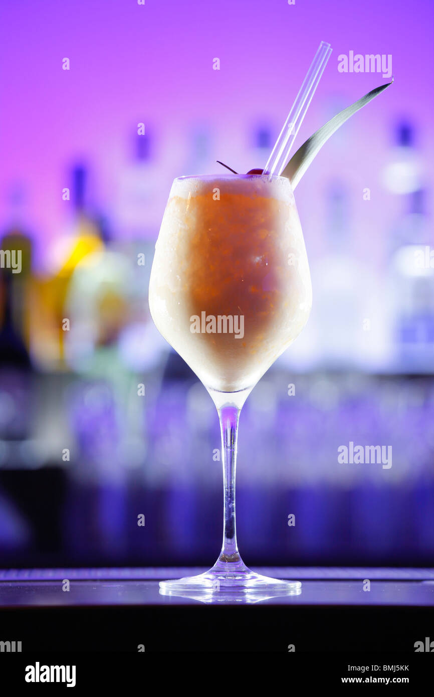 Pina Colada cocktail sur un bar, fond violet Banque D'Images