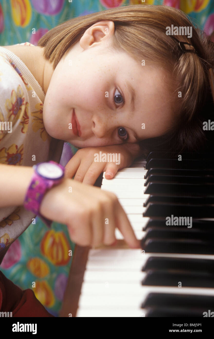 Petite fille assise avec la tête sur les touches de piano jouant un air  Photo Stock - Alamy