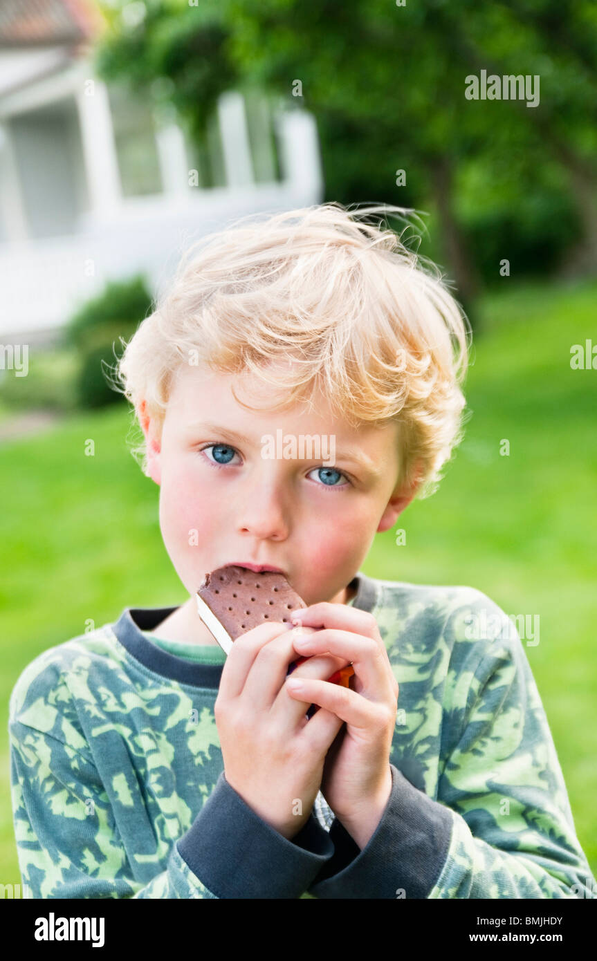 Boy eating ice cream l'extérieur Banque D'Images