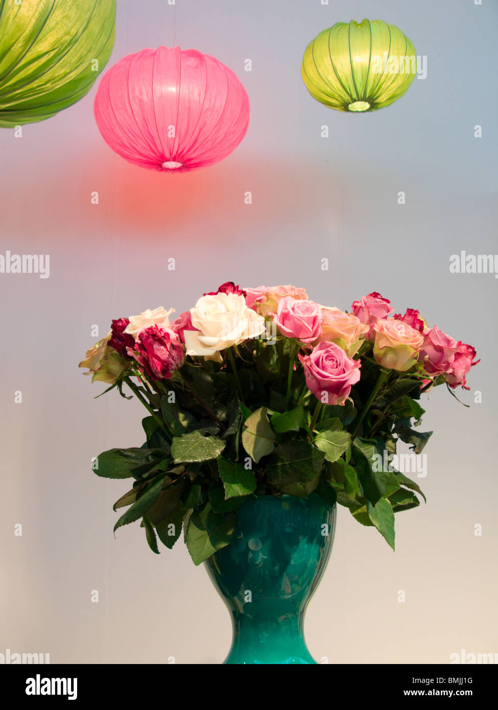 Lampes de plafond rose et vert et roses dans un vase, en Suède. Banque D'Images
