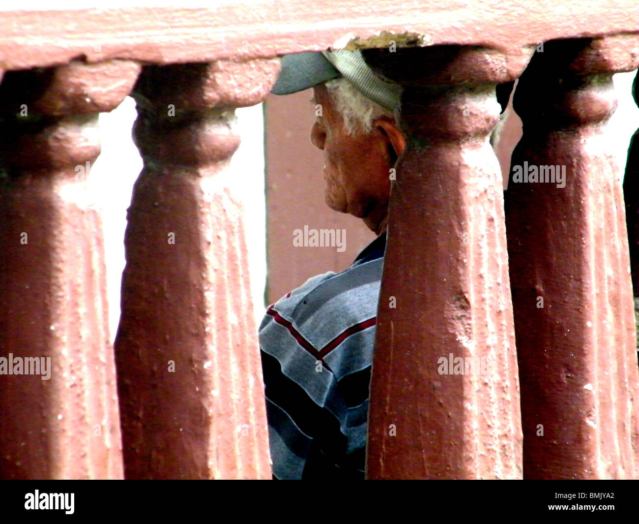 Un vieil homme est assis sans-abri contre un mur fissuré à Puerto Plata, République Dominicaine Banque D'Images