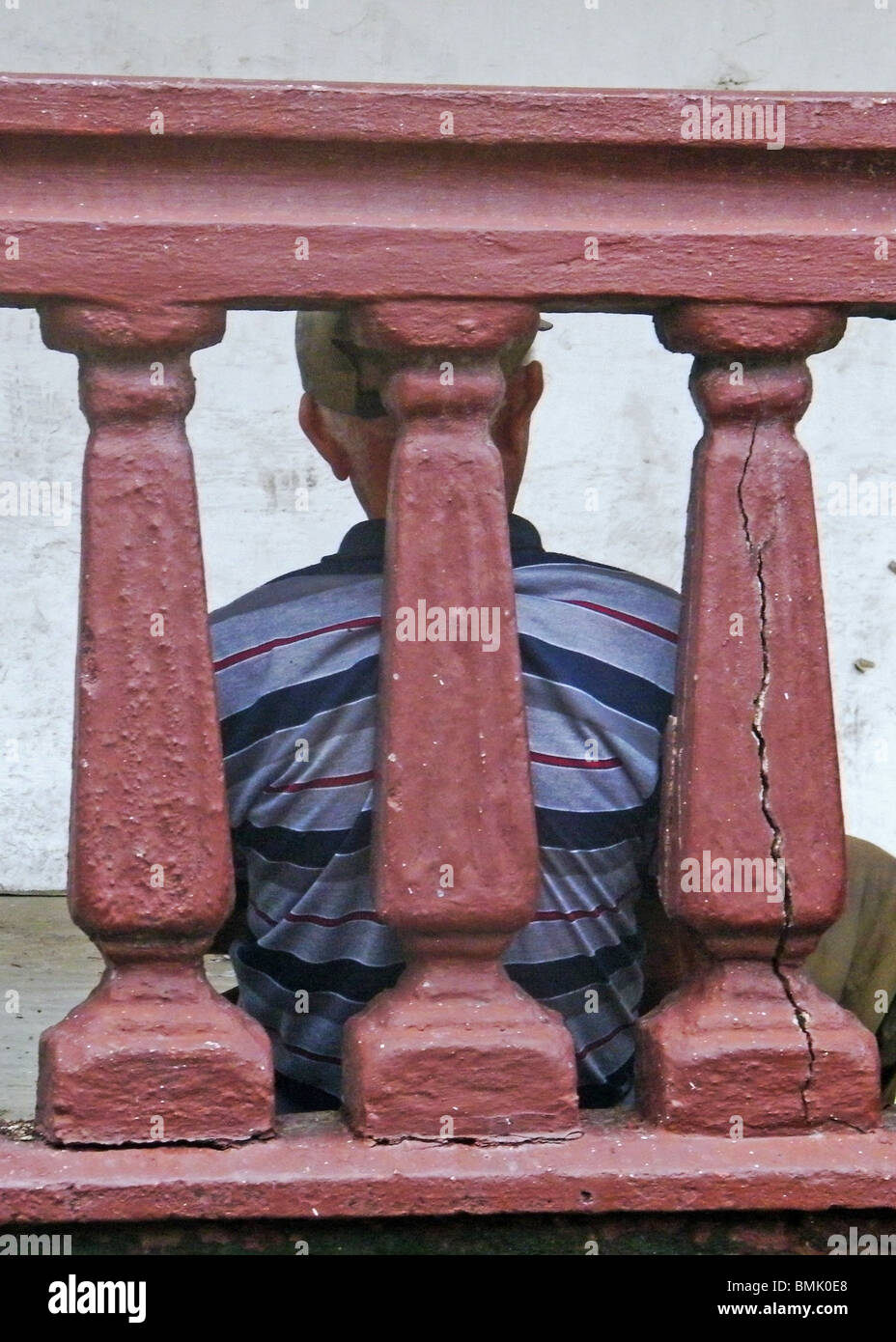 Un vieil homme est assis sans-abri contre un mur fissuré à Puerto Plata, République Dominicaine Banque D'Images