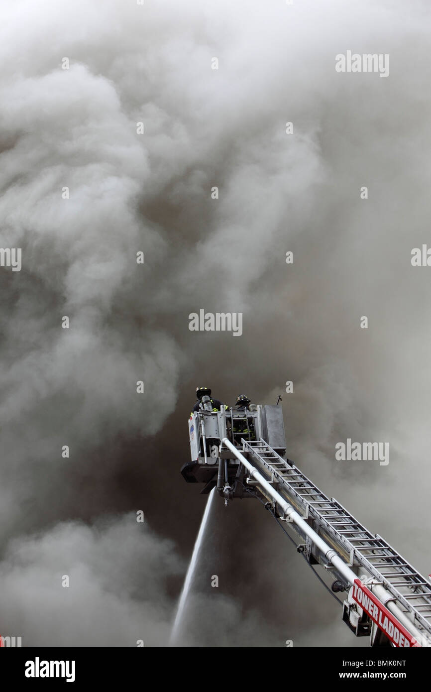 Pompier luttant contre un smoky blaze Banque D'Images