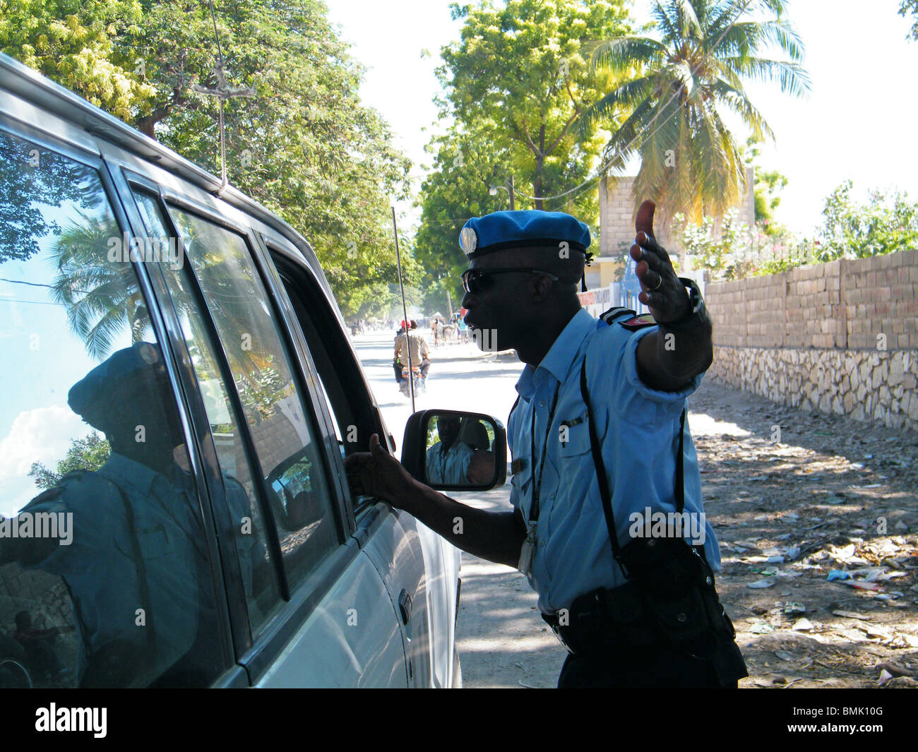 Un policier arrête un chauffeur à un barrage routier à la périphérie de Gonaïves, Haïti Banque D'Images