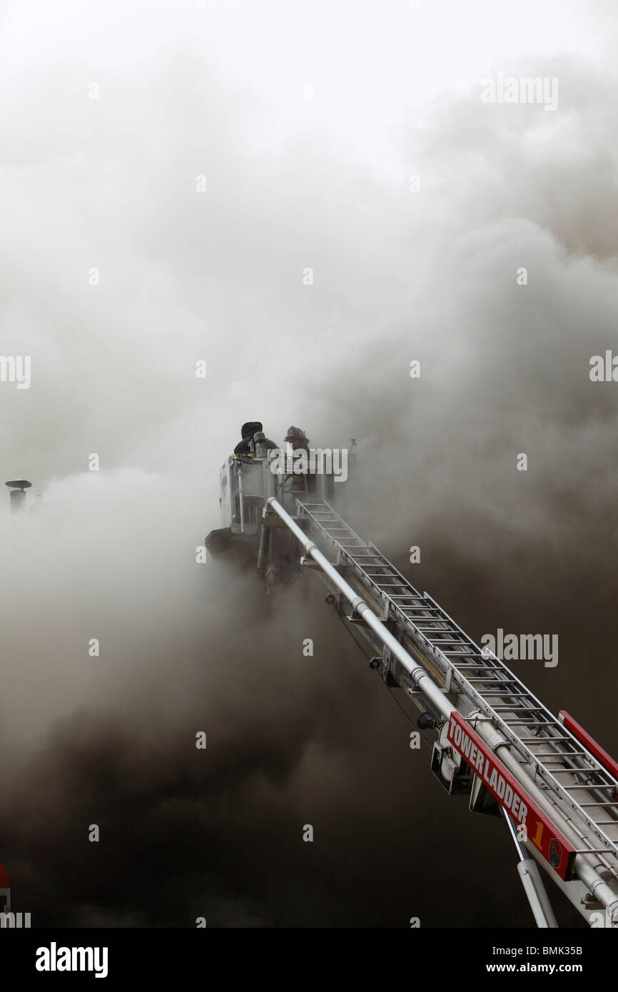 Pompier luttant contre un smoky blaze Banque D'Images