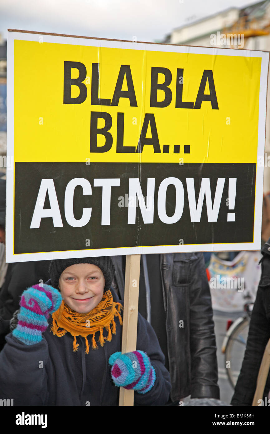 Smiling Young boy holding affiche de la démonstration et de mars en face de bâtiment du Parlement européen à Copenhague à la Conférence des Nations Unies sur le Changement Climatique COP 15. Banque D'Images