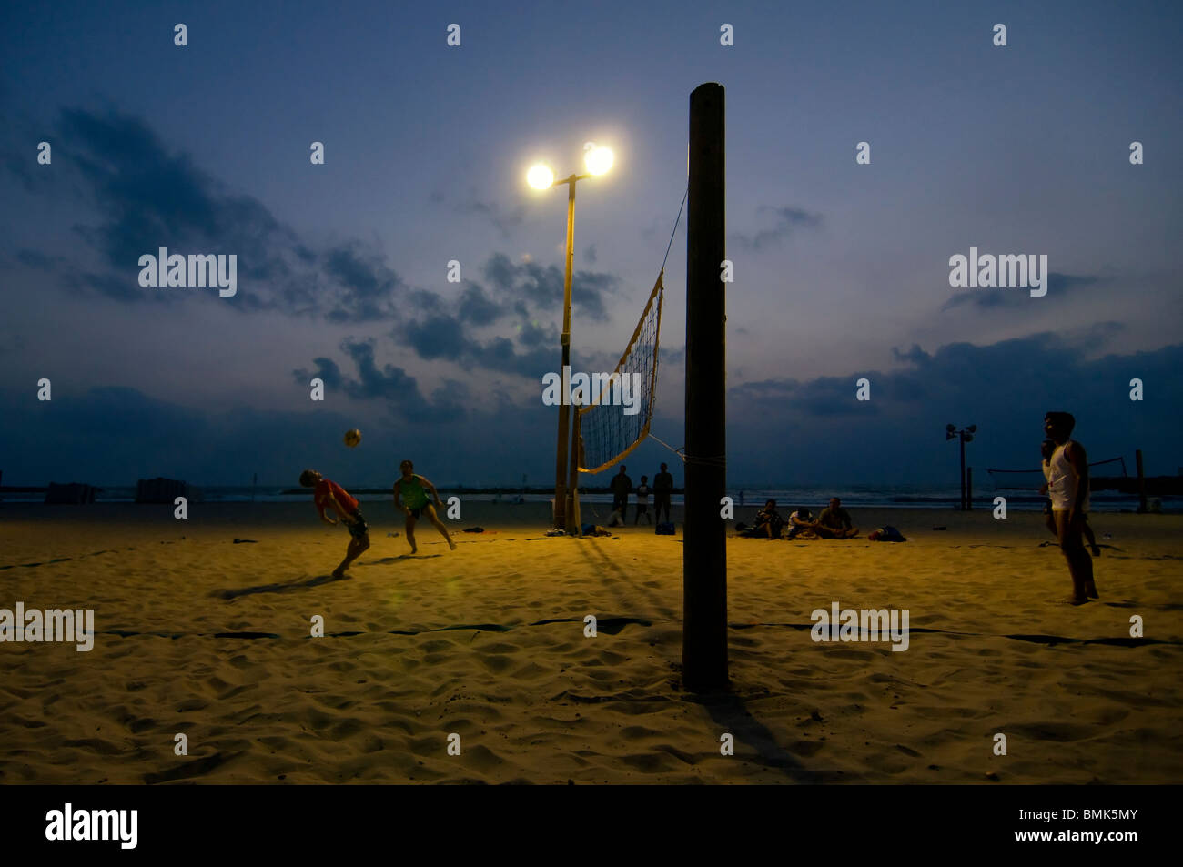 Les gens jouent au Beach-volley au coucher du soleil sur la plage de Gordon, sur le bord de mer méditerranéen de tel Aviv en Israël Banque D'Images