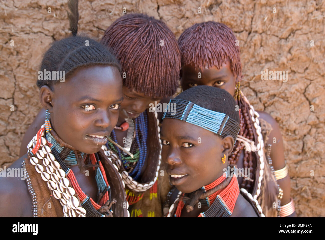 Ethiopie : Abaisser le bassin de la rivière Omo, Turmi, marché lundi, quatre jeunes femmes Hamar dans leurs perles et cuirs, avec deux cheveux ochred Banque D'Images