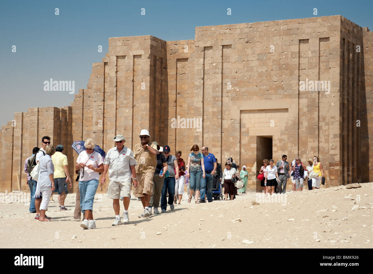 Les touristes visitant Saqqara, avec une partie de l'ancien mur calcaire restauré dans l'arrière-plan, Saqqara, Egypte Banque D'Images