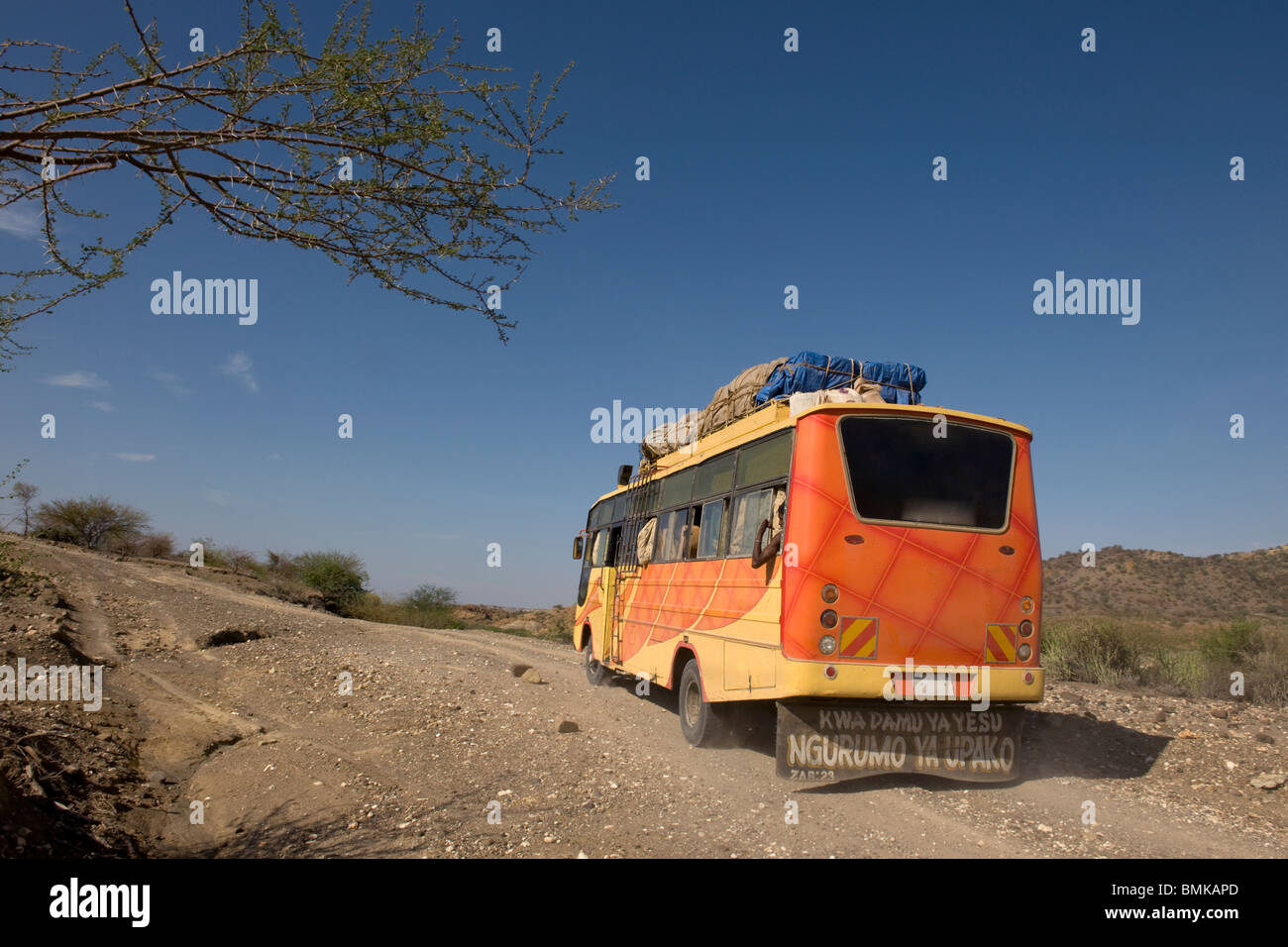 Vue arrière du bus se déplaçant sur le chemin de terre, Tanzania, Africa Banque D'Images