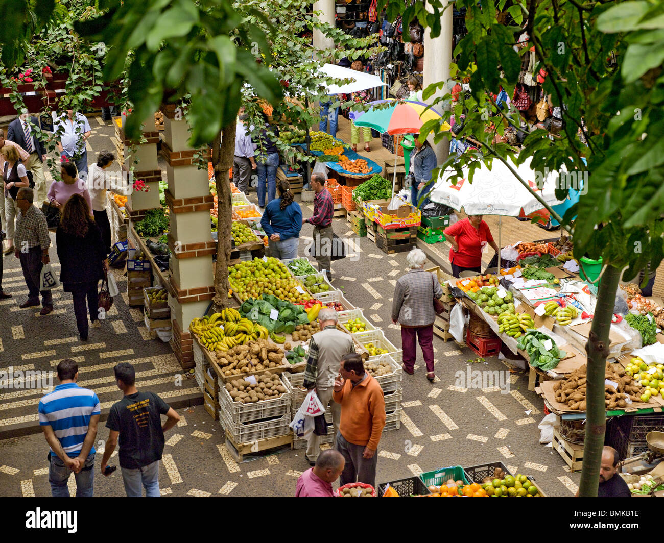 Les gens qui achètent des fruits et légumes frais sur des étals du Marché Agricole Mercado dos Lavradores Funchal Madère Portugal Europe de l'UE Banque D'Images