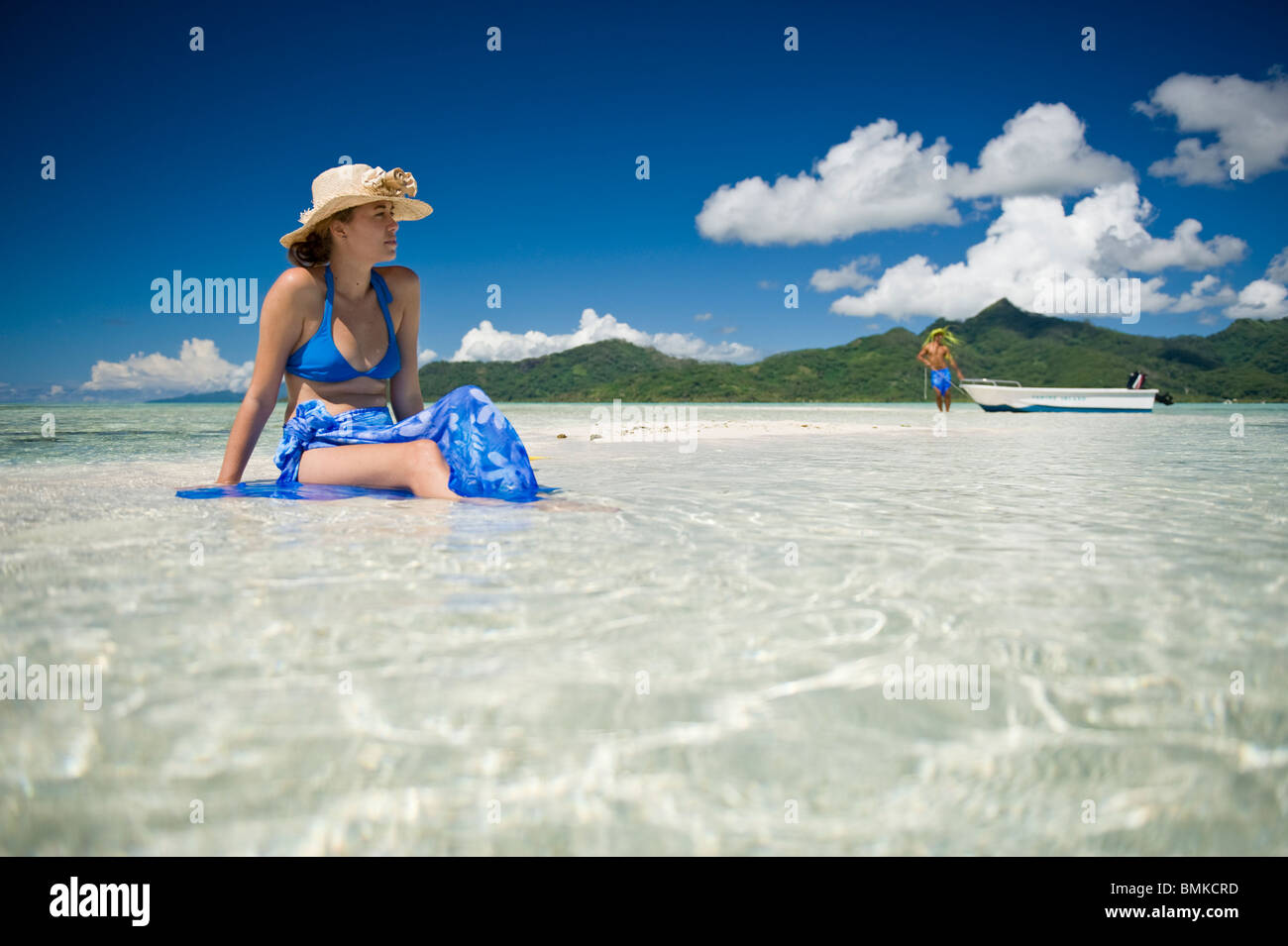 Un homme assis sur une plage de sable blanc Banque D'Images