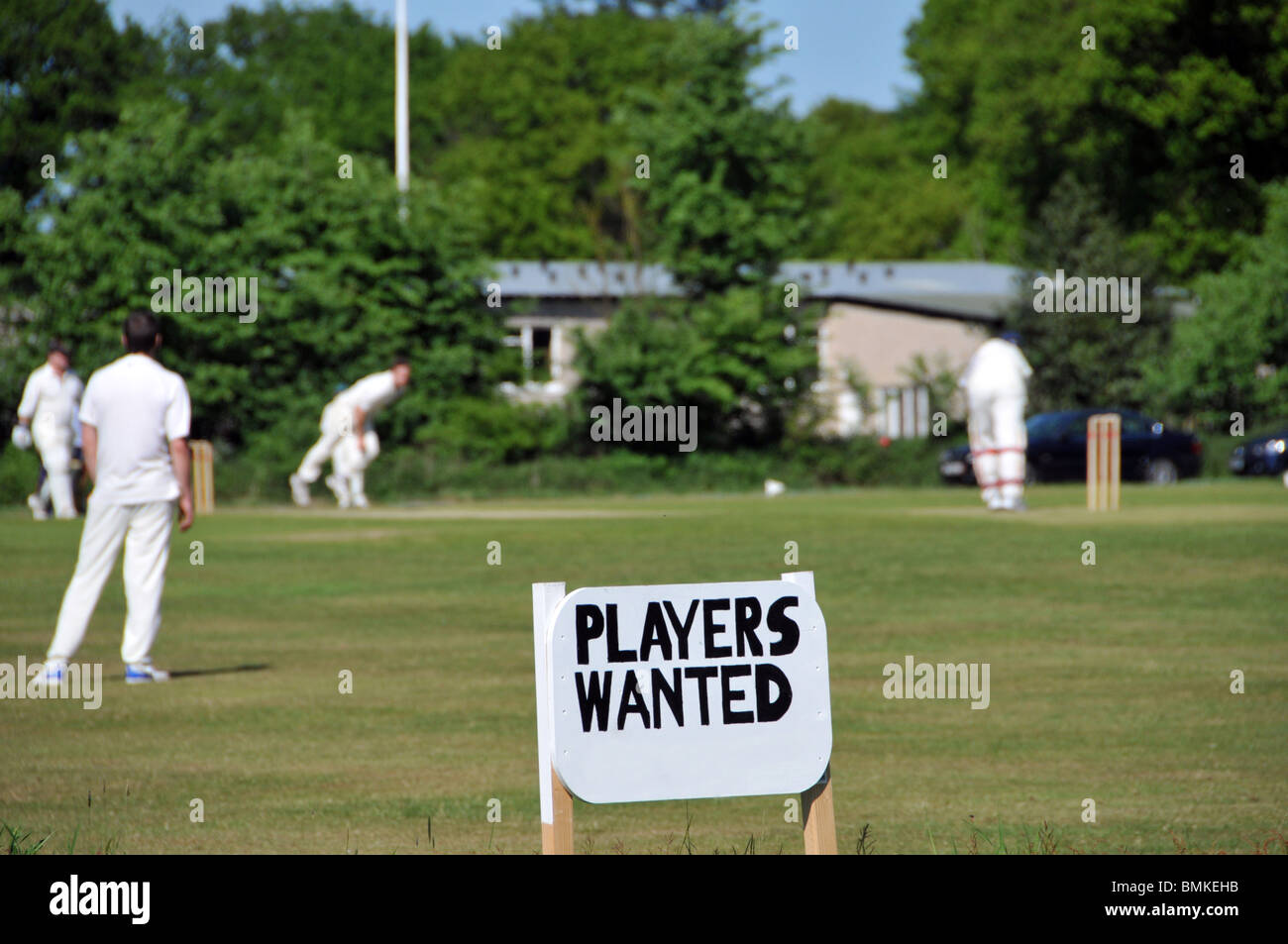 Village vert compétition amatuer match de cricket d'été en cours et signe publicitaire pour les joueurs recherché Navestock Brentwood Essex Angleterre Royaume-Uni Banque D'Images