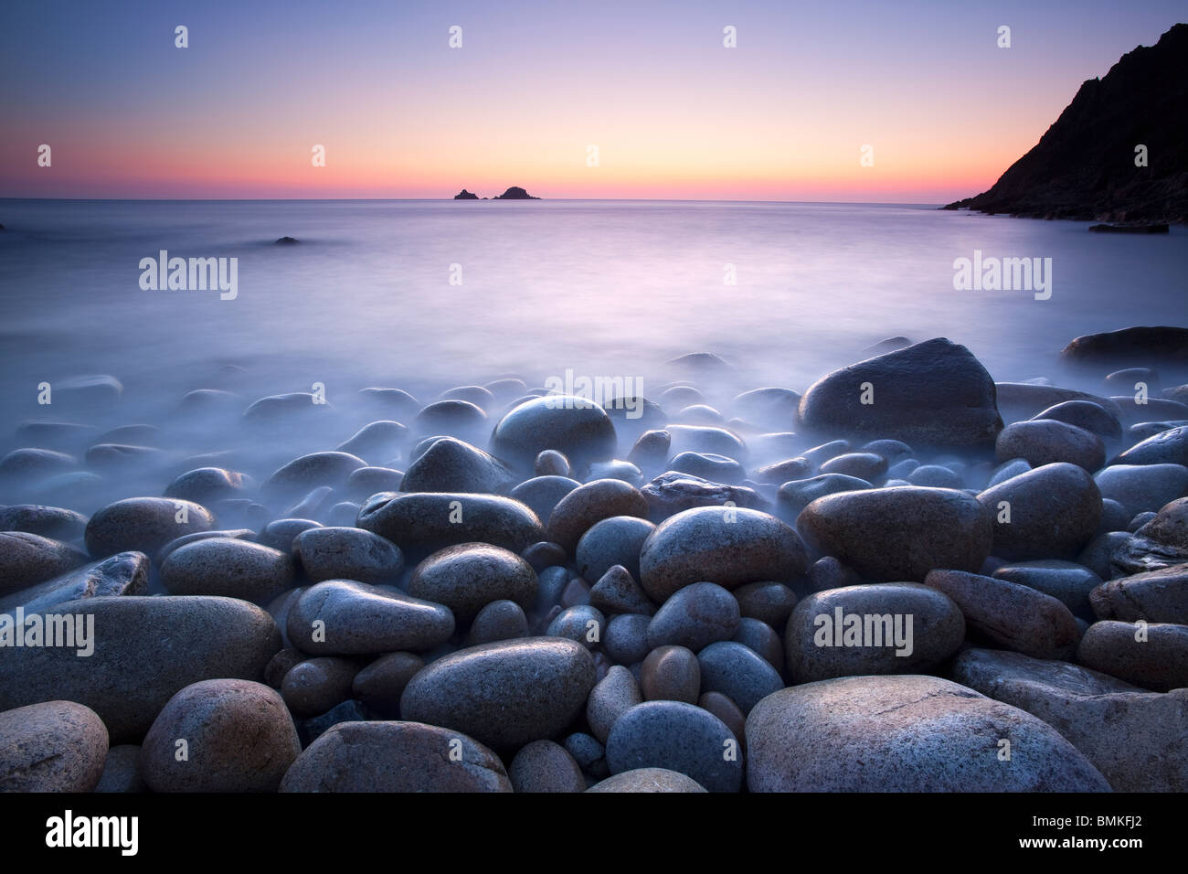 Des rochers sur la plage au coucher du soleil Cornwall Banque D'Images