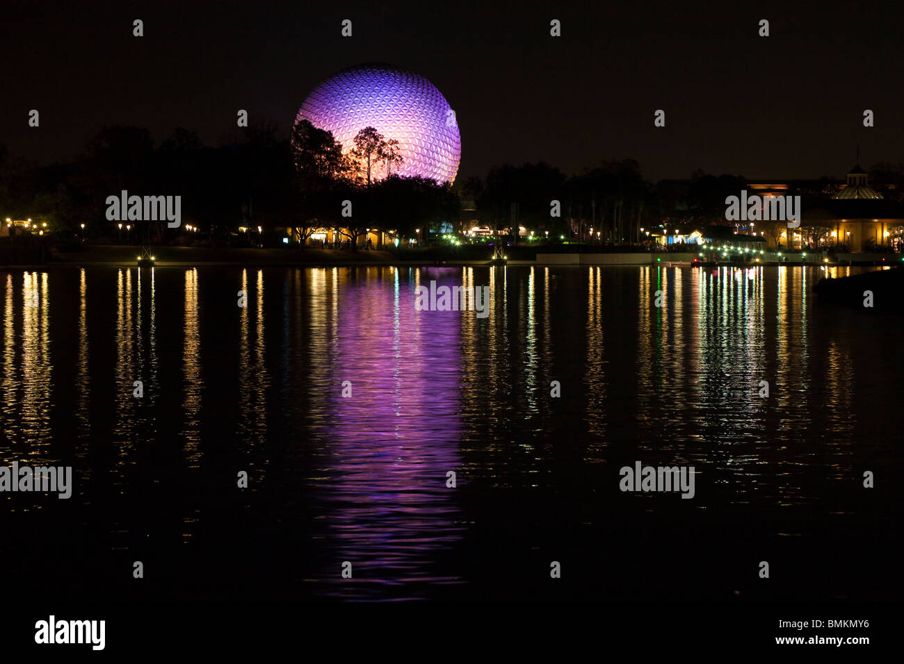 Dôme géodésique de Spaceship Earth attraction éclairé avec des lumières violettes se reflète sur le lac de nuit dans Walt Disney's Epcot Center Banque D'Images
