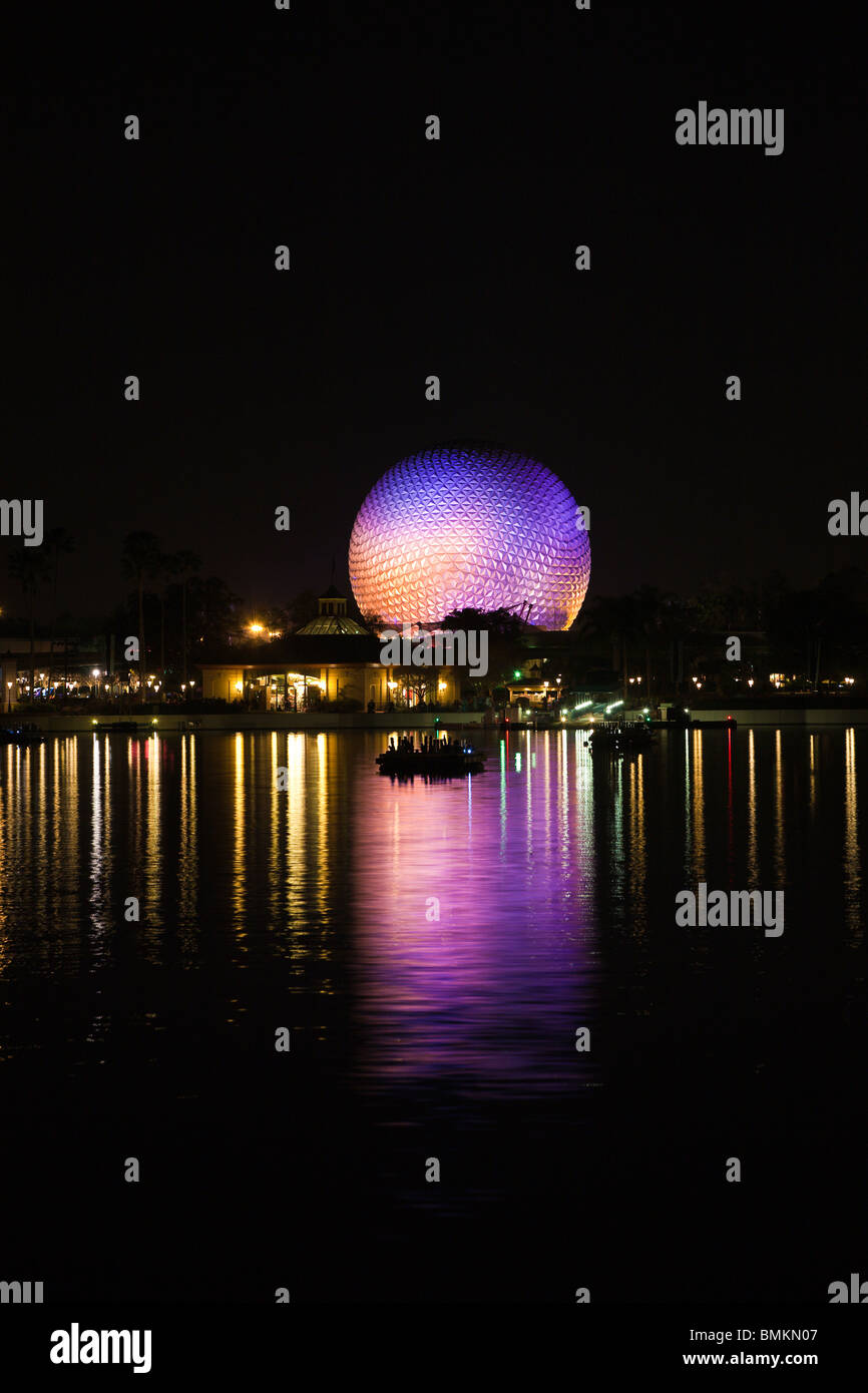 Dôme géodésique de Spaceship Earth attraction éclairé avec des lumières violettes se reflète sur le lac de nuit dans Walt Disney's Epcot Center Banque D'Images