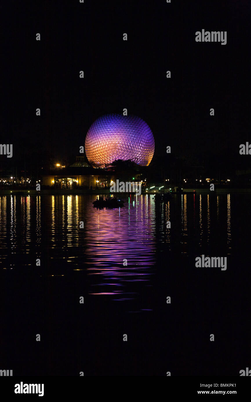 Dôme géodésique de Spaceship Earth attraction éclairé avec des lumières violettes se reflète sur le lac de nuit dans Walt Disney's Epcot Center Banque D'Images