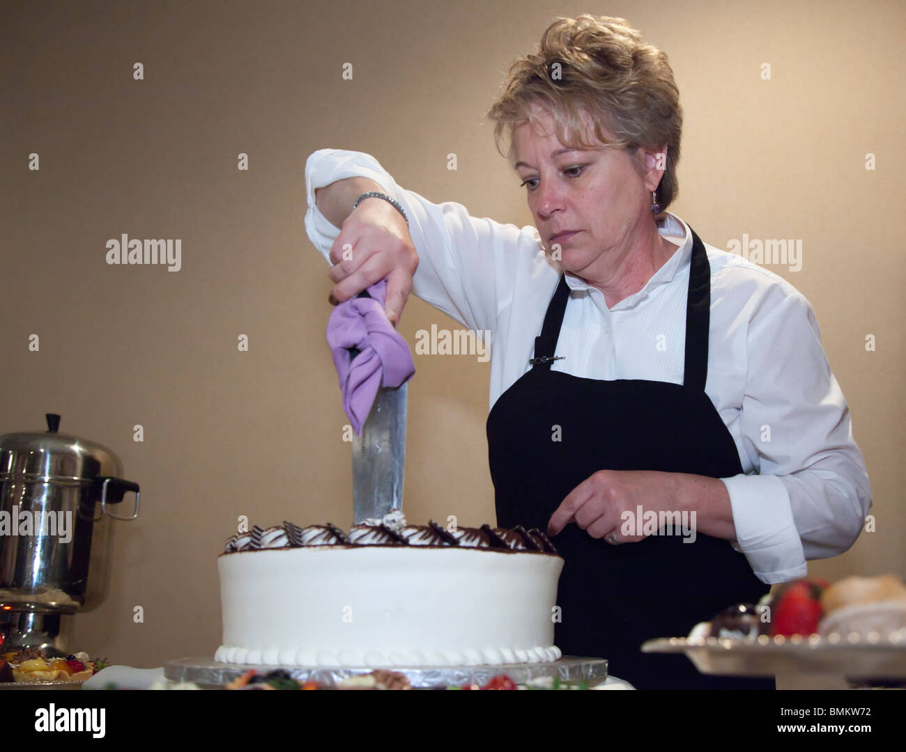 Detroit, Michigan - Un employé de restauration coupe le cake à l'occasion d'un mariage. Banque D'Images