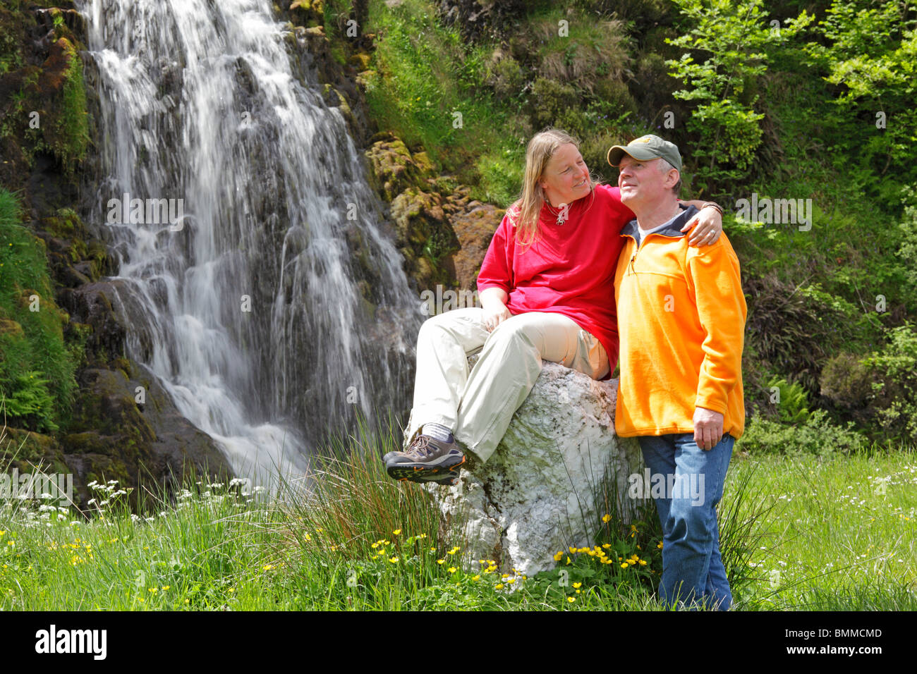 Un couple posant devant une cascade près de Donegal Ardara, Co., République d'Irlande Banque D'Images