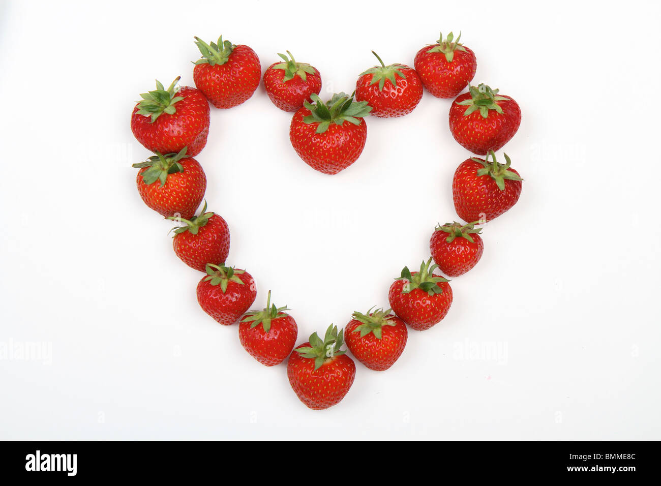 Fraises rouges en forme de coeur d'amour sur un fond blanc. Banque D'Images