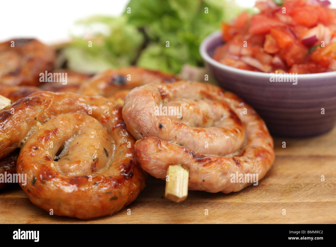 Plats préparés ou BBQ Saucisses de Cumberland avec une salsa de tomates fraîches feuilles de salade et pas de personnes Banque D'Images