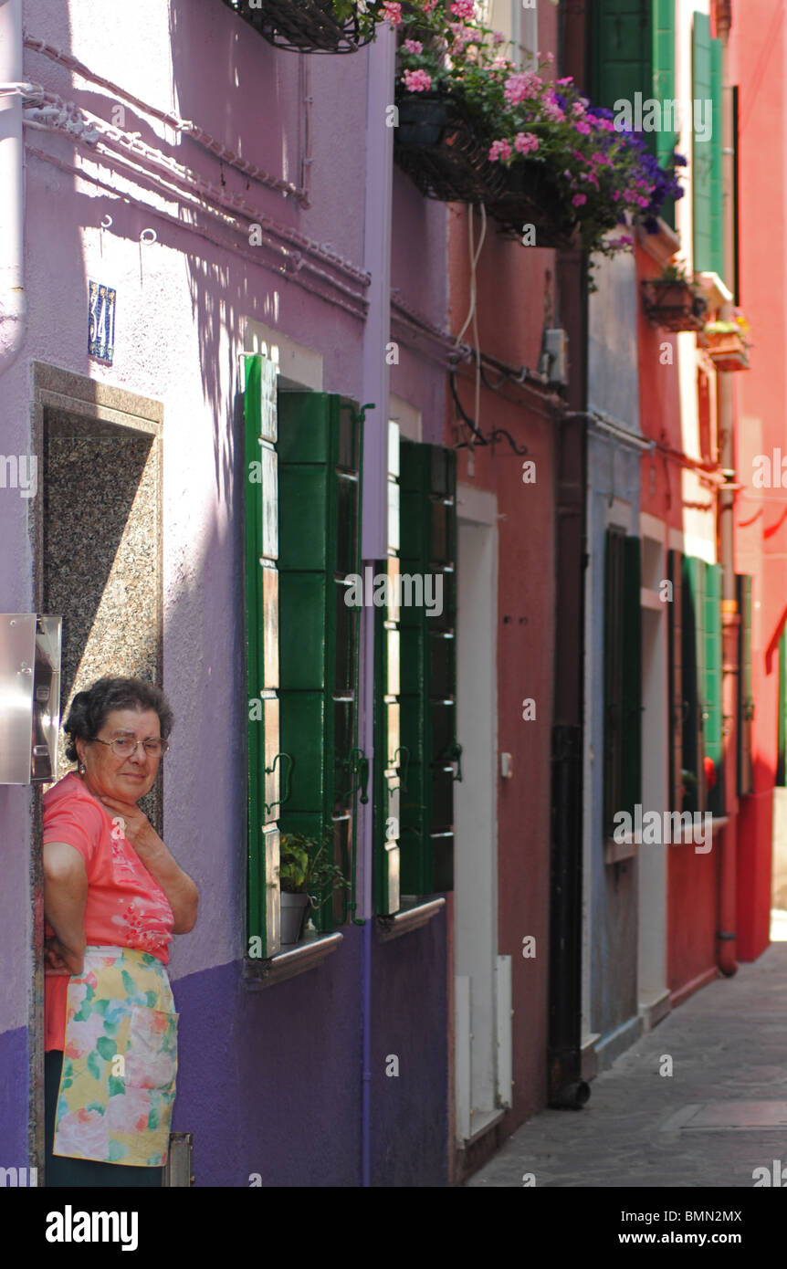 Une femme à la porte de sa maison, Burano, Italie Banque D'Images