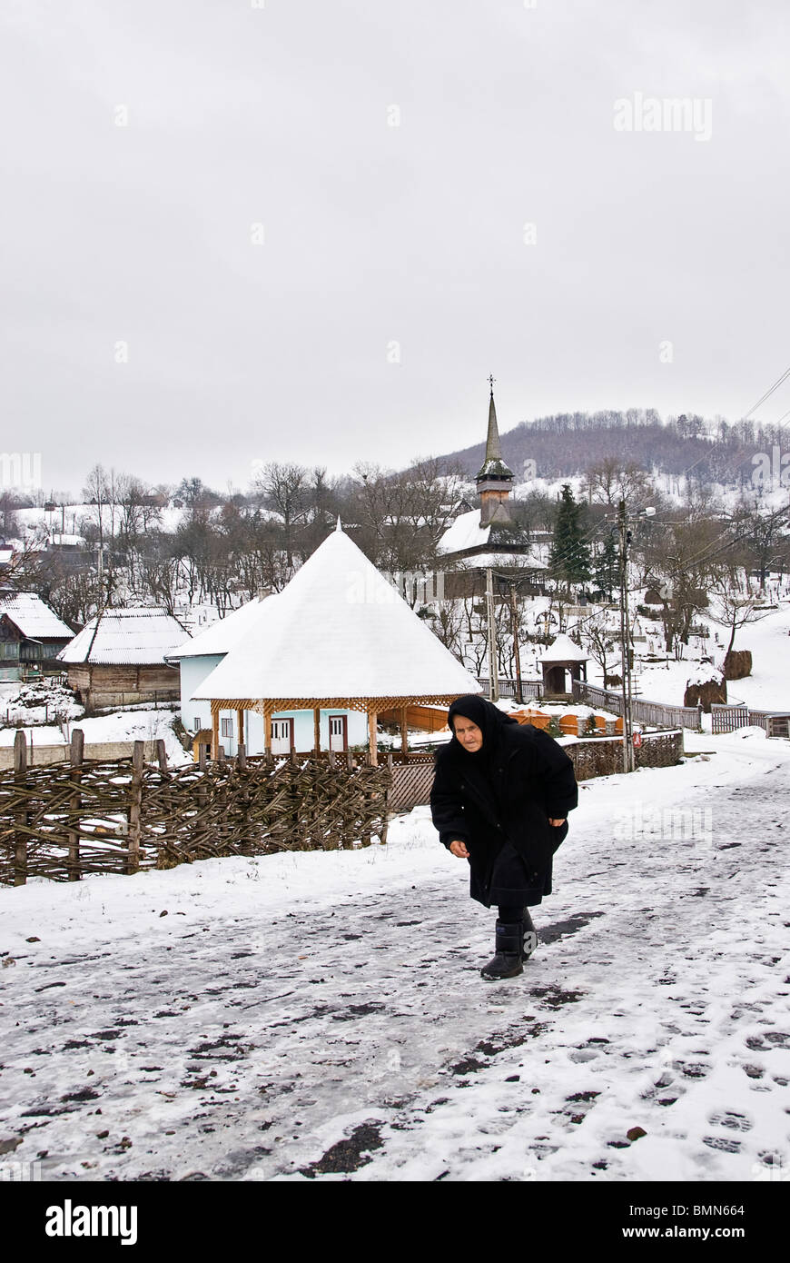Vieille Femme qui sort de l'église, Maramures, Roumanie, Europe. Banque D'Images