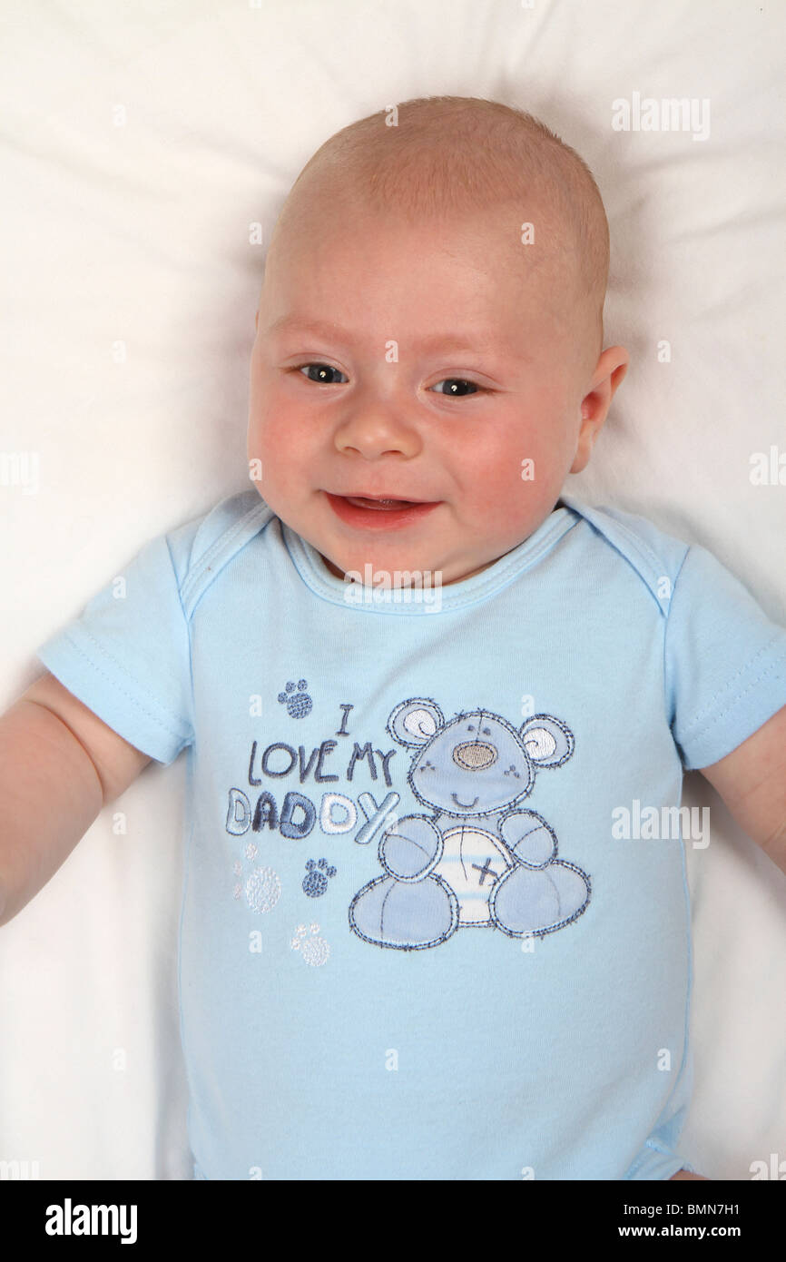 Smiling Caucasian baby boy wearing a blue 'J'aime mon papa' bébé grandir Banque D'Images