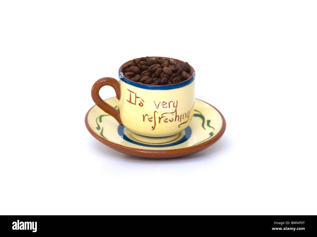 Tasse pleine de grains de café frais dans une tasse et soucoupe de devise-ware.Le dicton est qu'il est très rafraîchissant.Espace de texte. Banque D'Images