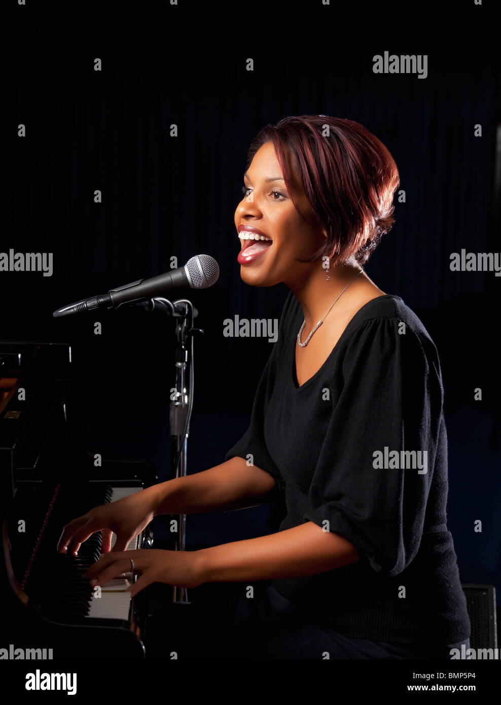 Fort Lauderdale, Floride, États-Unis d'Amérique ; une femme jouant du piano  et chante dans un micro Photo Stock - Alamy