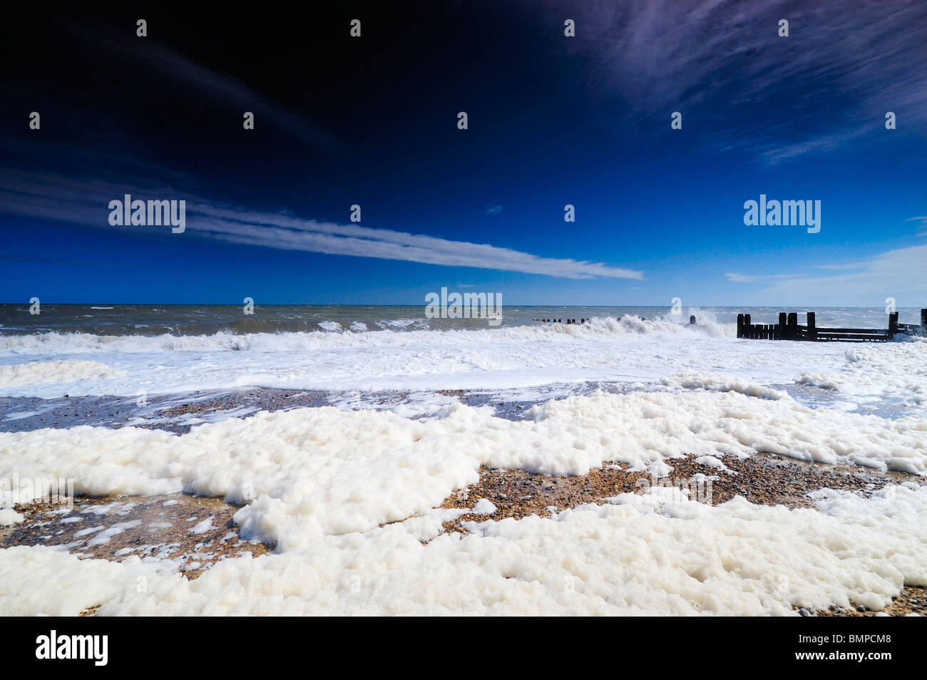 Écume de mer sur la plage de Walcot, Norfolk UK Banque D'Images