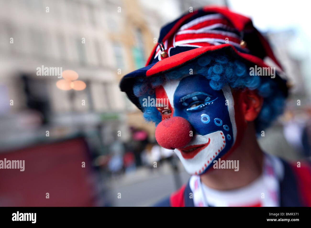 Un clown vêtus aux couleurs du drapeau britannique dans Piccadilly Circus, Londres, Angleterre. Banque D'Images