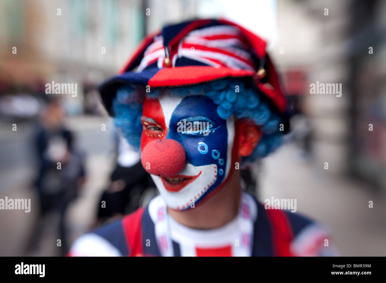 Un clown vêtus aux couleurs du drapeau britannique dans Piccadilly Circus, Londres, Angleterre. Banque D'Images