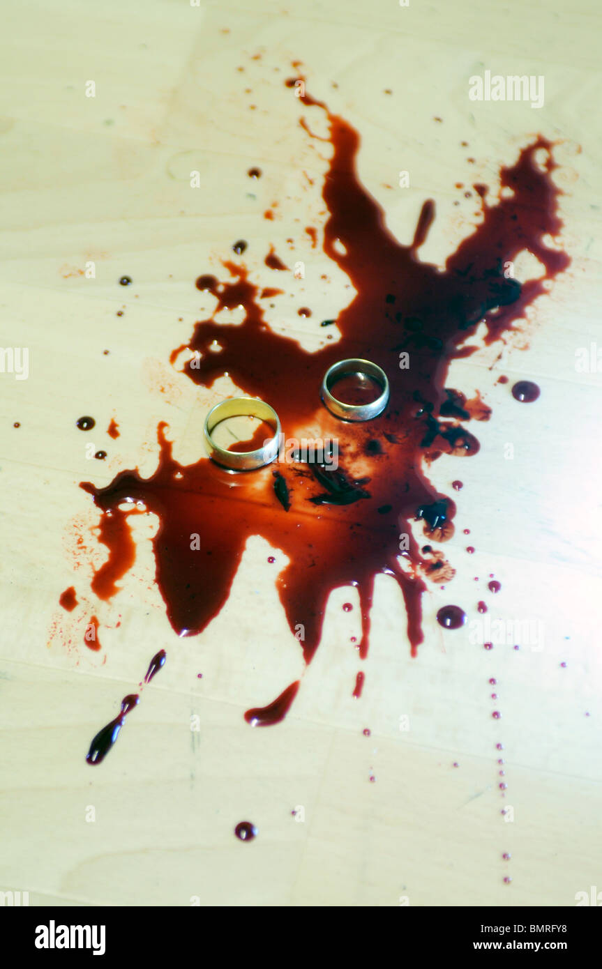 Une paire de bagues de mariage couché dans une tache de sang Banque D'Images